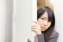 会議の様子をドアの隙間から覗く女性社員